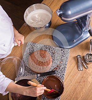 Chocolate cake baking ingredients on kitchen table with kitchenware, top view