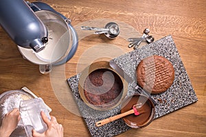 Chocolate cake baking ingredients on kitchen table with kitchenware, top view