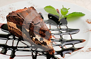 Chocolate cake with a brown topping and sprig of mint