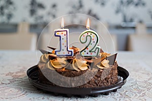 Chocolate cake with candles on day twelve of birth