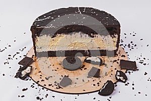 Chocolate cake with cheese filling is decorated with biscuits on a white background