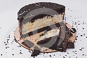 Chocolate cake with cheese filling is decorated with biscuits on a white background