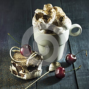 Chocolate cake with cherries and a cup of coffee with whipped cream.