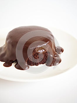 Chocolate cake with chocolate fudge. Served on white plate over