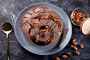 Chocolate cake with chocolate pieces on a metallic black background