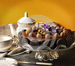 Chocolate cake with cookies and an candies on black table, tasty home made chocolate cake.