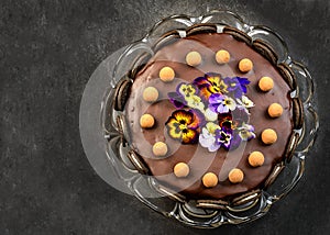 Chocolate cake with cookies and an candies on black table, tasty home made chocolate cake.