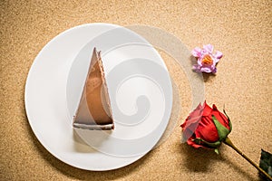 Chocolate cake on dish with flower