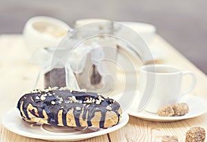 Chocolate cake (eclair) with cup of coffee.