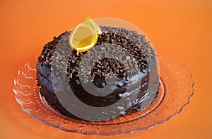 Chocolate cake with ganache, shavings and orange peel photo
