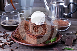 Chocolate cake with ice cream on plate on wood table.