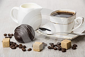 Chocolate cake, jug milk, pieces of sugar and coffee cup