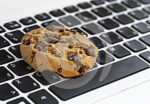 Chocolate cake on keyboard symbol of internet cookies