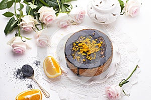 Chocolate cake with orange and icing. On a white background, and a bouquet of white roses. Good morning with a surprise and