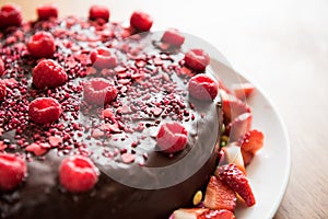 Chocolate cake with raspberries and strawberries slices