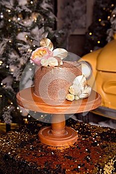 Chocolate cake with raspberry filling and pistachio cream, decorated with roses and golden jelly sparkles in the New