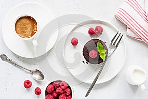 Chocolate cake served with raspberries and cup of espresso coffee