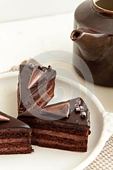 Chocolate cake slice with curl on white background. cake with whipped cream and mascarpone filling. Delicious naked cake filled