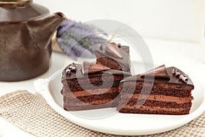 Chocolate cake slice with curl on white background. cake with whipped cream and mascarpone filling. Delicious naked cake filled