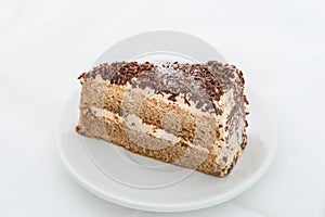 Chocolate cake slice with curl on white dish