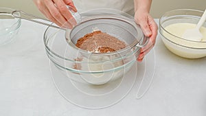 Chocolate cake step by step recipe. Mixing dry ingredients - flour, cocoa powder, baking powder - in a glass bowl