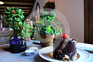 Chocolate cake with strawberries on top, sprinkled with nuts on