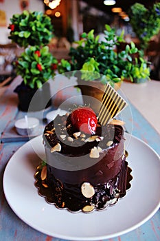 Chocolate cake with strawberries on top, sprinkled with nuts on