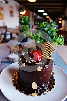 Chocolate cake with strawberries on top, sprinkled with nuts on