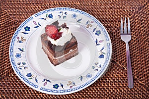 Chocolate cake with strawberry,fork and hand