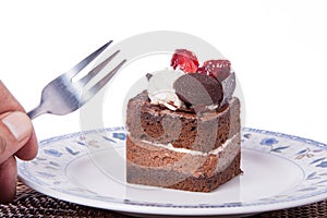 Chocolate cake with strawberry,fork and hand