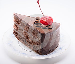 Chocolate cake with topping cherry in ceramic plate. Delicious cuisine dessert over white background