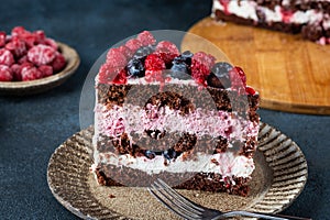 Chocolate cake with whipped cream and fresh berries. Piece of raspberry cake. Blueberry cake. Portion of cake. Summer