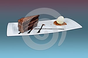 Chocolate cake on a white plate with ice cream on a purple and light blue background