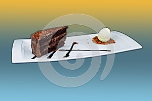 Chocolate cake on a white plate with ice cream on a yellow and light blue background