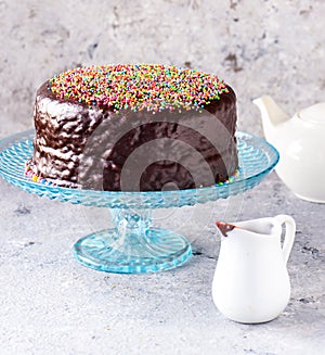 Chocolate cake with with white teapot at tea time