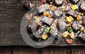 Chocolate candies, candied fruits on a wooden background