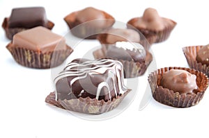 Chocolate candies in a candy wrapper on a white background. A set of sweets with different tastes ..