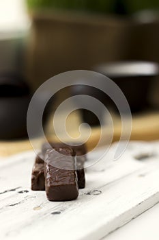 Chocolate candies on clay teapot background