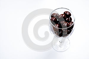 Chocolate candies in a clear glass cup. white background with text area