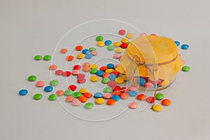 Chocolate candies, small multi-colored in a jar with a bow.