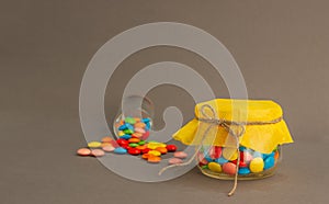 Chocolate candies, small multi-colored in a jar with a bow.