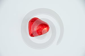 Chocolate candy wrapped in red foil, heart-shaped