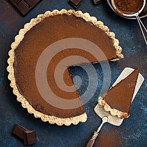 Chocolate and caramel tart on dark blue background