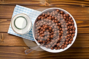 Chocolate cereals in bowl and milk in jar