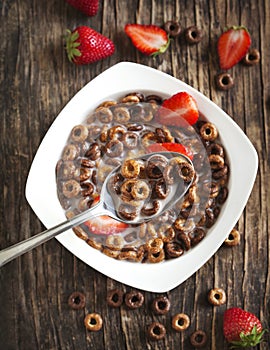 Chocolate cereals and strawberries for breakfast closeup.