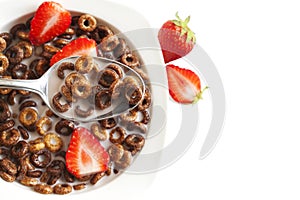 Chocolate cereals and strawberries for breakfast closeup.