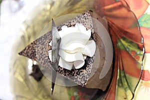 Chocolate cheesecake decorated with white cream flower and chocolate leaf