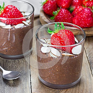 Chocolate chia seed pudding garnished with almond slices and strawberry, square format