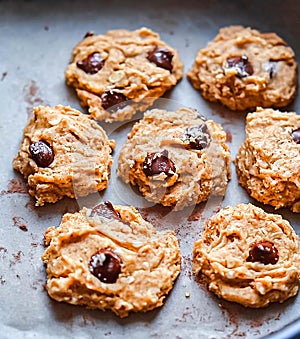 Chocolate chip cookie dough scooped on a cookie sheet ready to be baked