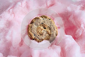Chocolate chip cookie on pink cotton candy.